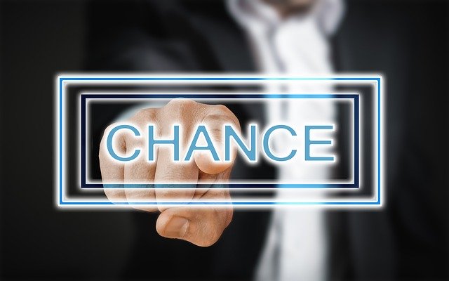 Mann im dunklen Anzug verschwommen im Hintergrund tippt auf durchsichtigen, mit dem Wort Chance beschrifteten Button